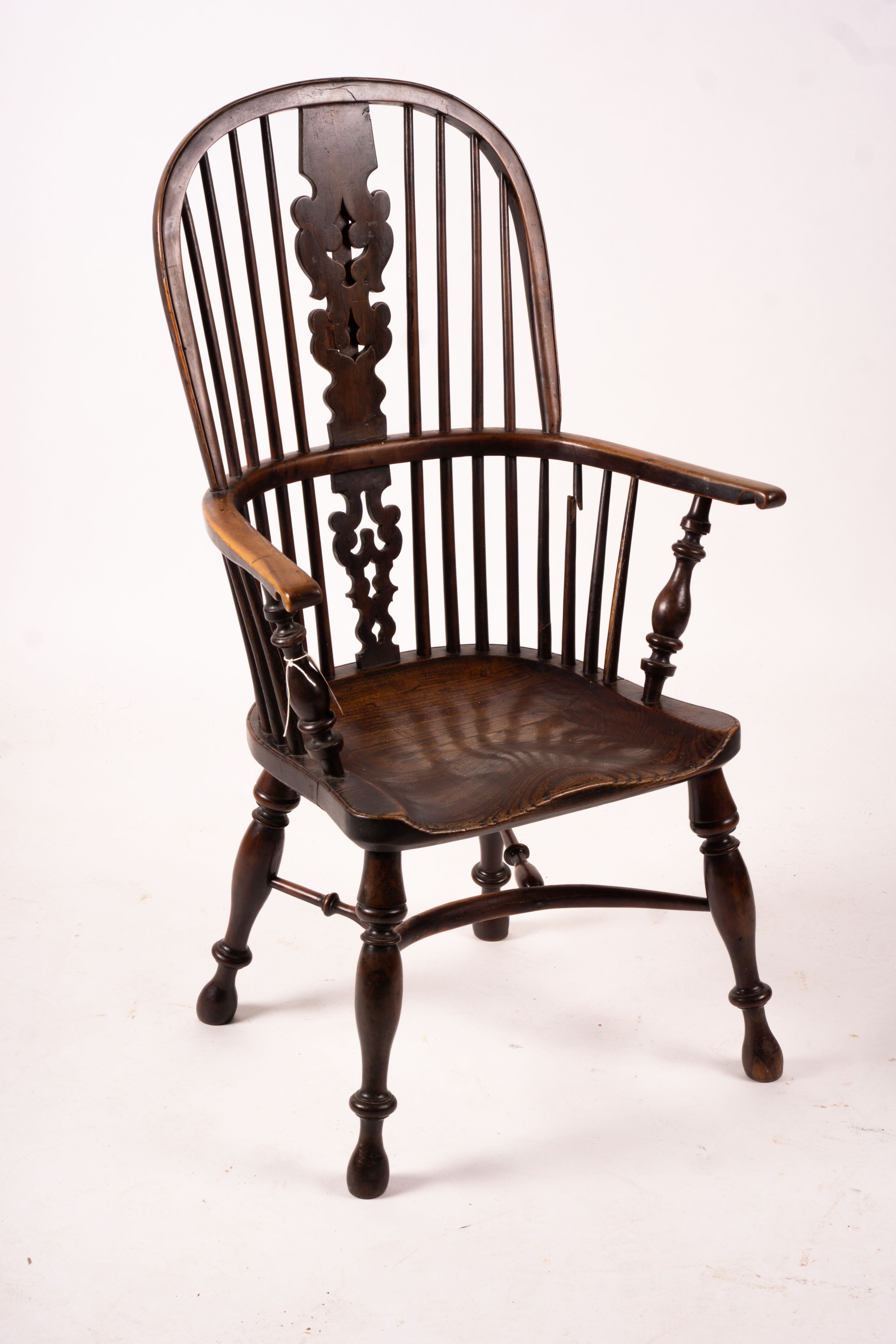 A mid 19th century yew and elm Yorkshire area Windsor armchair with saddle-seat and crinoline stretcher, width 63cm, depth 47cm, height 110cm